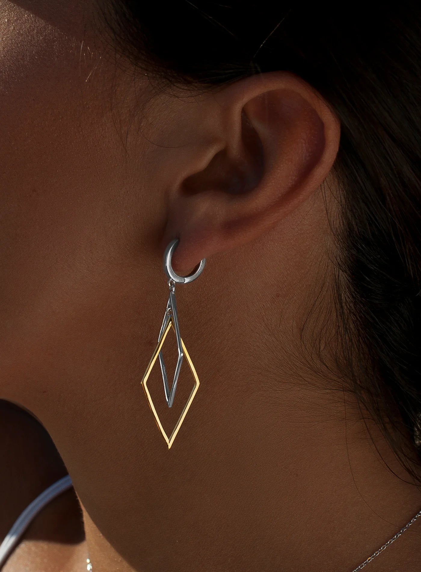 Long two-tone silver earrings with a rhombus design